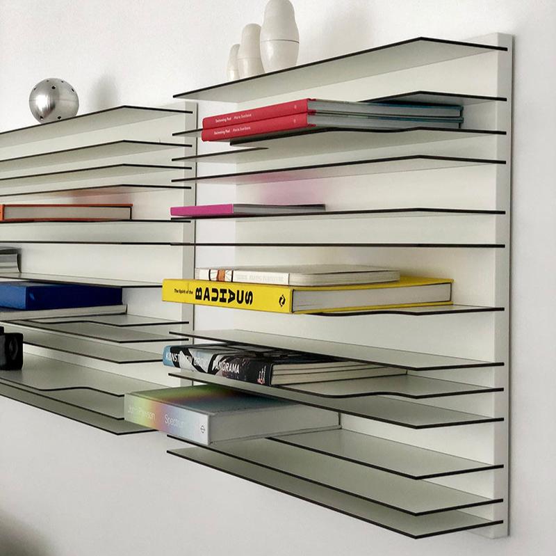 Spectrum Paperback shelving system featuring thin, minimalistic shelves displaying colorful books and decorative objects.