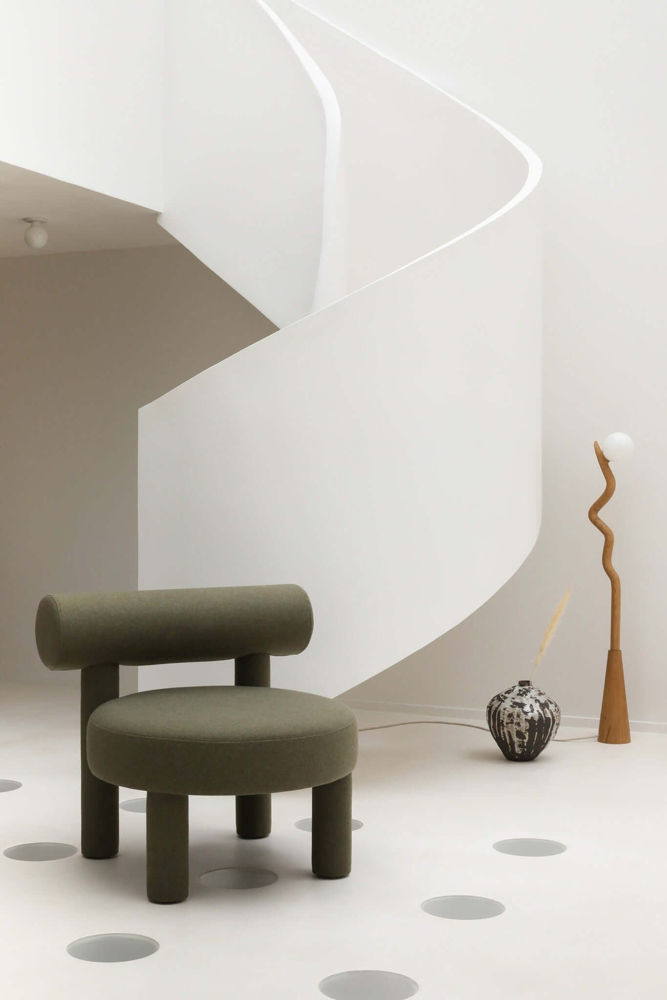 Gropius Low Chair CS1 by Noom with Bauhaus-inspired design in modern minimalist room with spiral staircase.