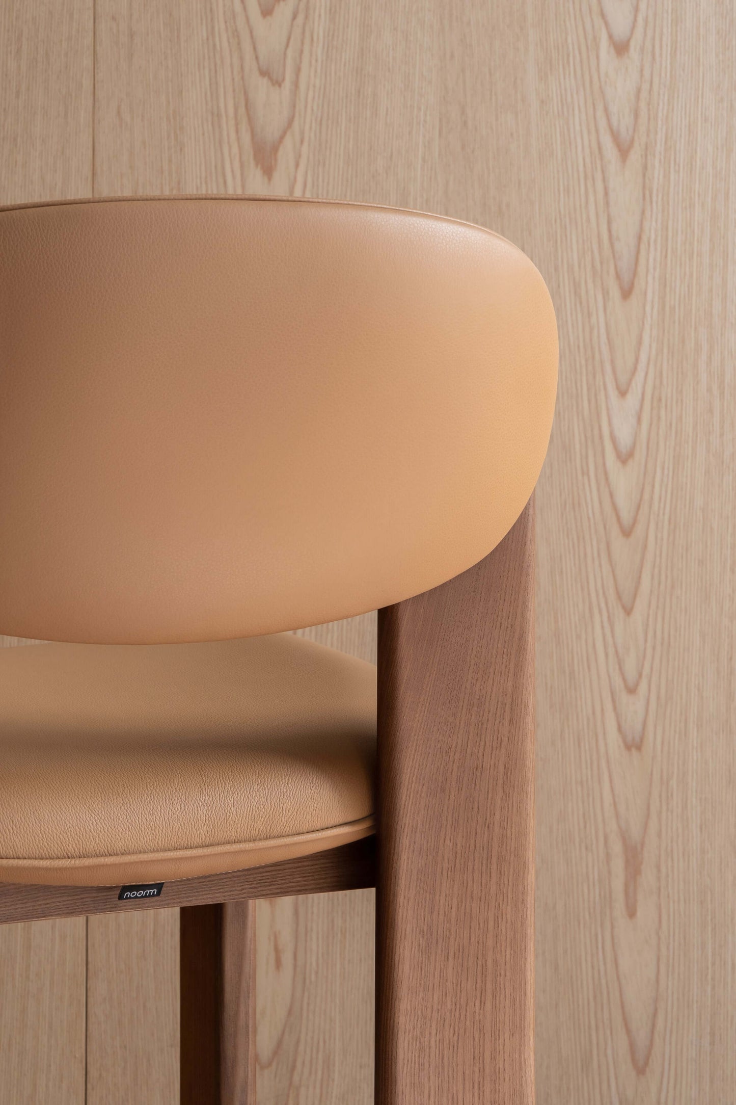 Minimalist Archipen chair by Noom with a sleek design and wooden finish, inspired by Olexander Archipenko's kinetic art.