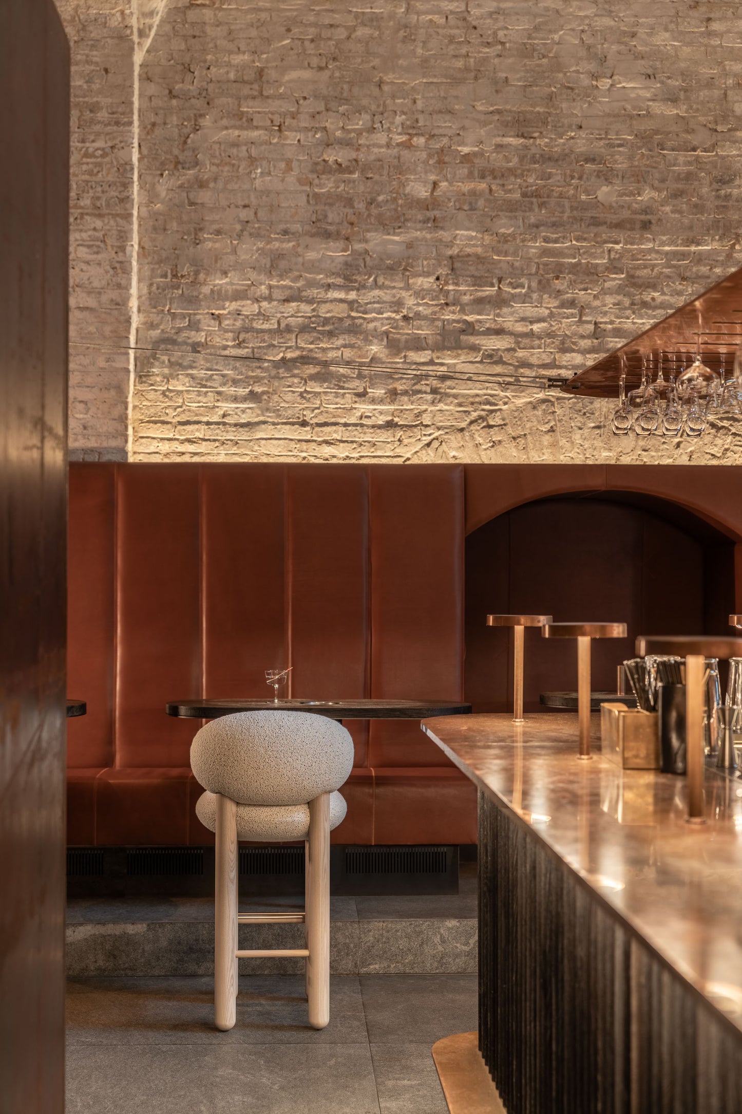Modern Flock CS2 bar stool in a stylish interior with a long wooden bar and red upholstered seating.