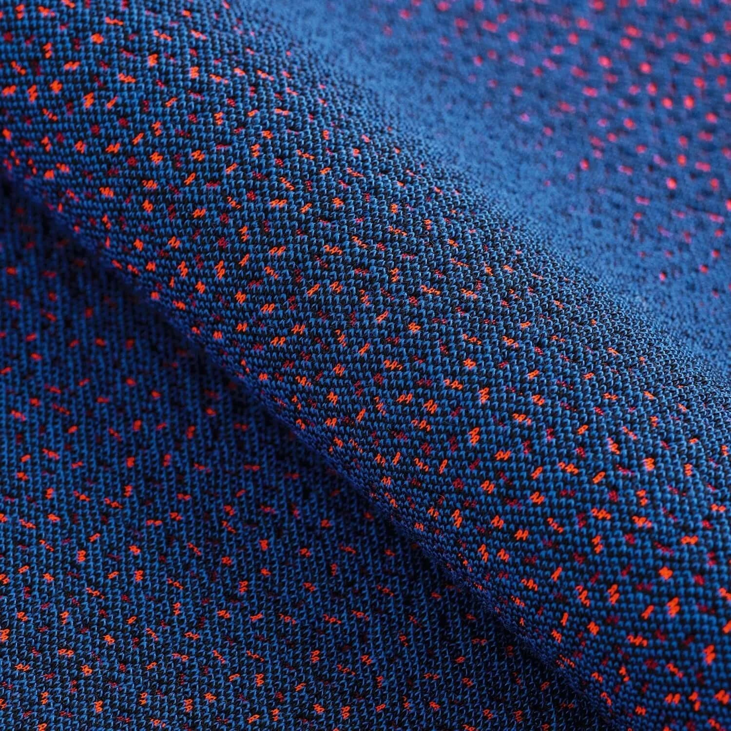 Close-up of modern blue fabric with red and orange patterns, showcasing texture and design details.