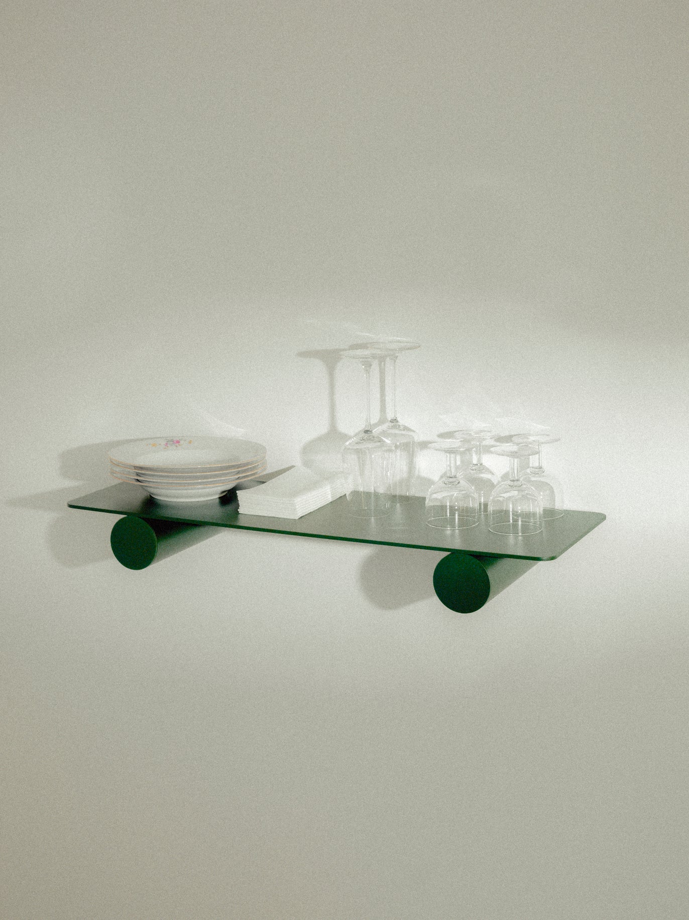 Pipeline Duo shelf by Raawii featuring modern green metal design, showcasing plates and glasses in unique colours.