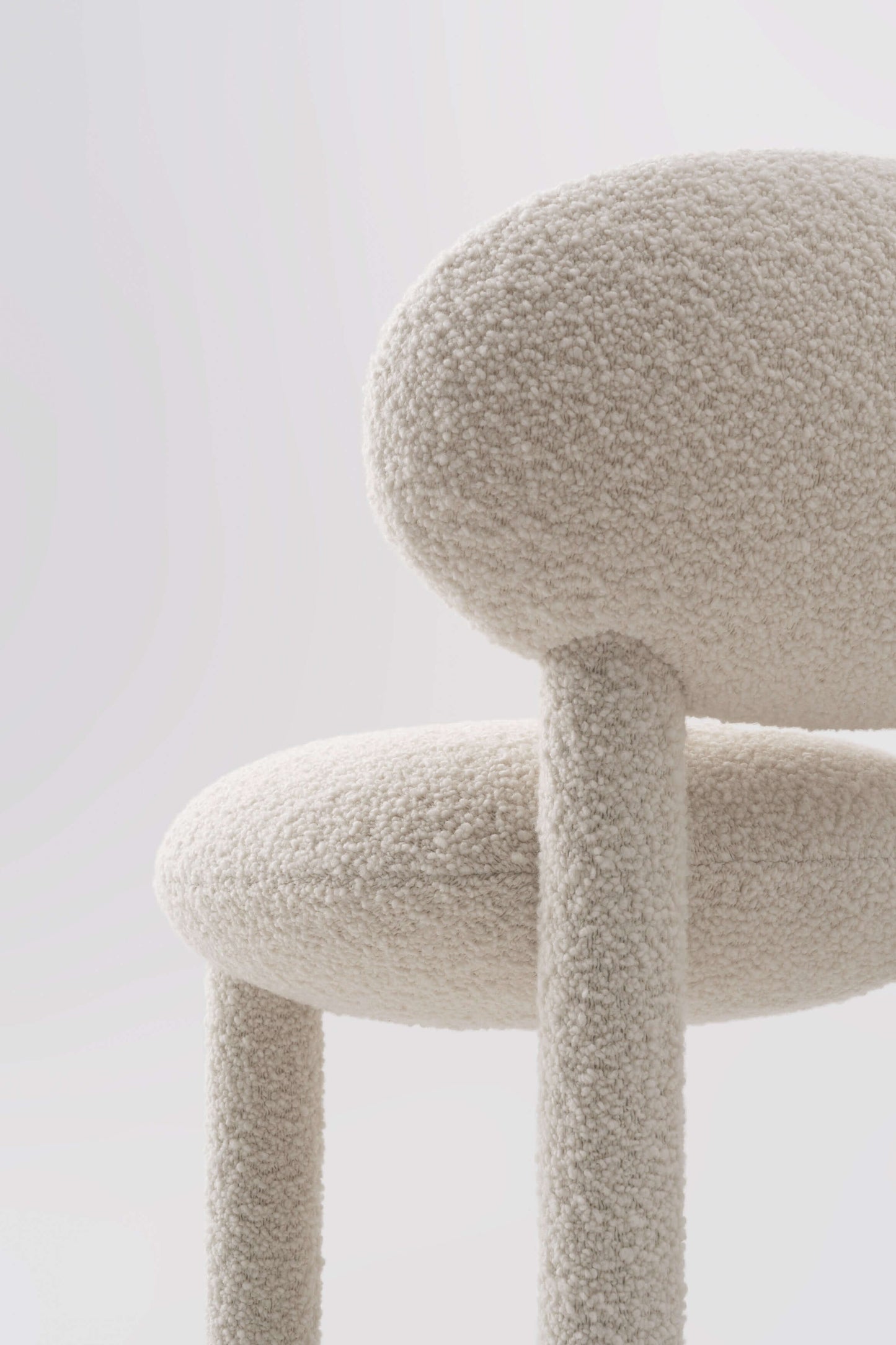 Modern designer flock dining chair by NOOM home, featuring soft textures and a unique shape in a neutral palette.
