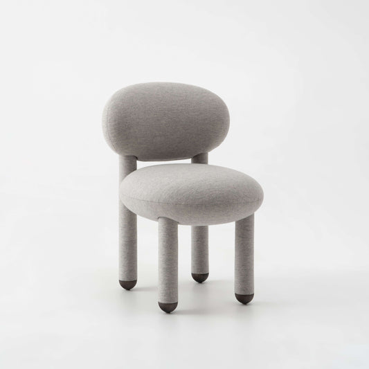 Modern designer Flock dining chair by NOOM home in soft gray upholstery, featuring rounded forms and natural materials.