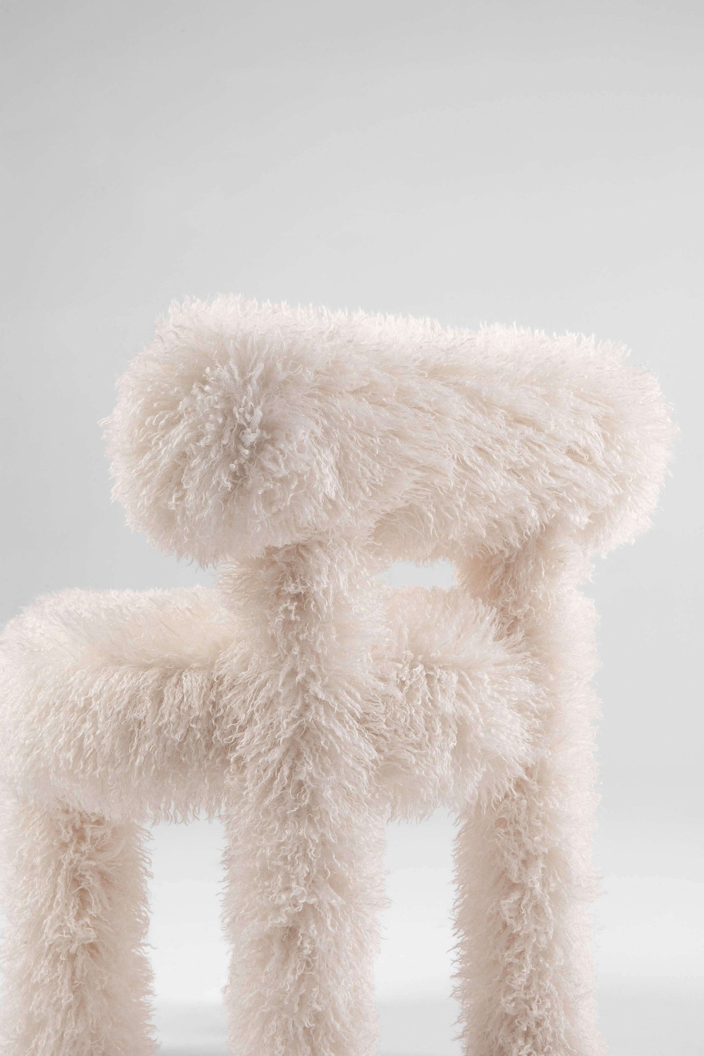 A close up of the Gropius Chair CS1 Fluffy Edition by Noom with entire textured white faux fur fabric designed by Kateryna Sokolova inspired by bauhaus