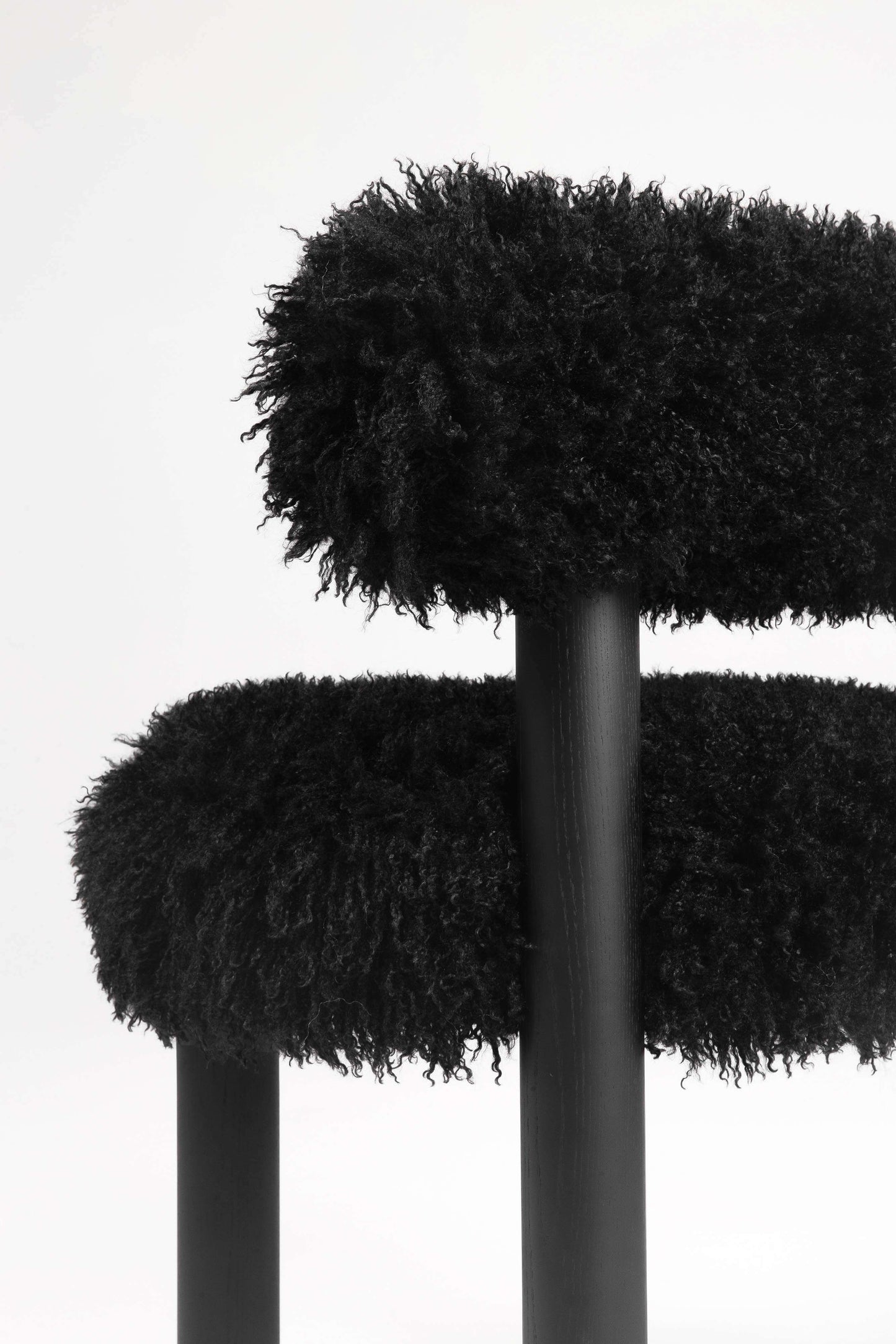 Close-up of black Gropius CS2 Fluffy Edition chair by Noom, highlighting its plush, textured upholstery and sleek design.
