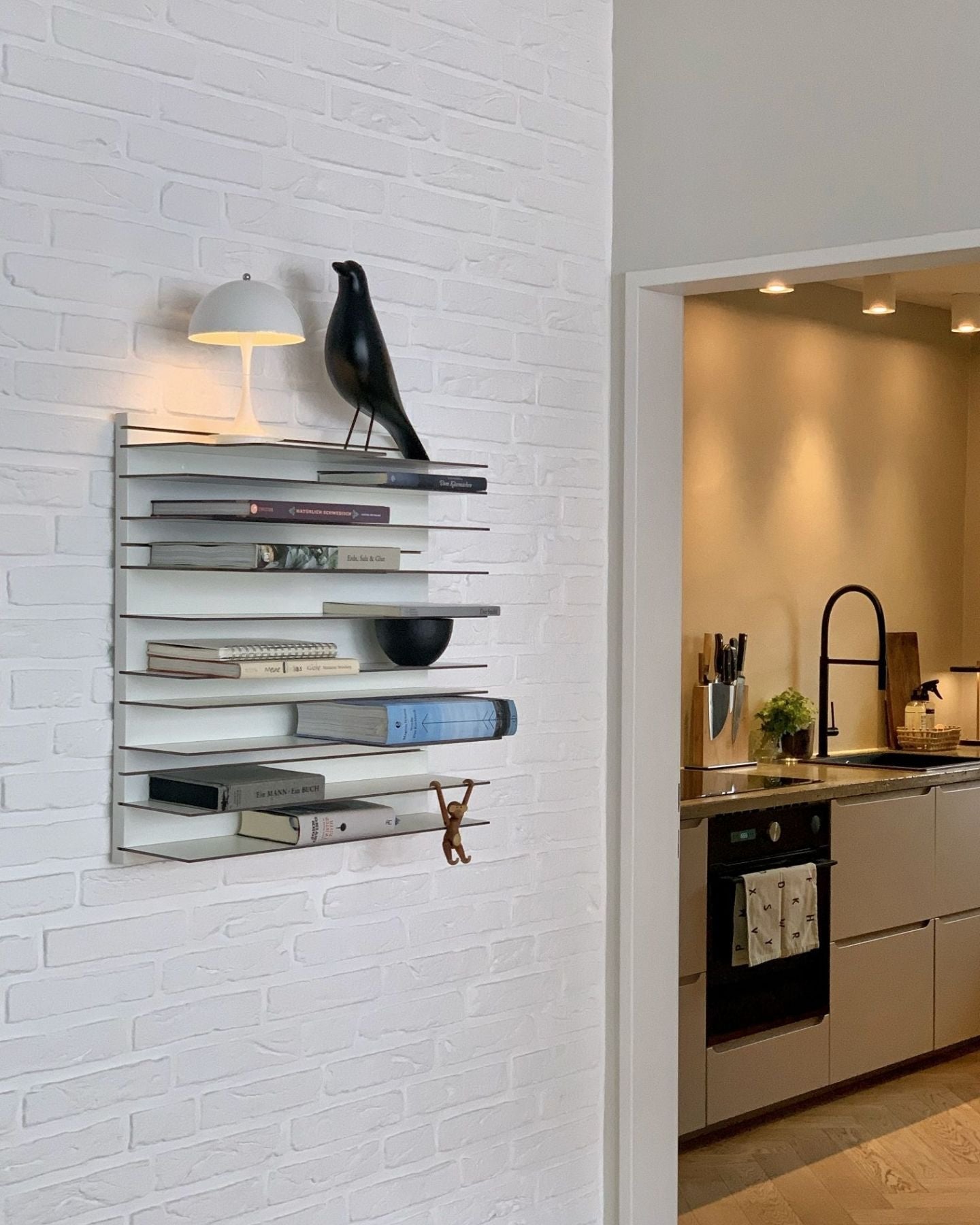 Spectrum Paperback shelving system displayed on a white wall, featuring books, decor, and a modern lamp.