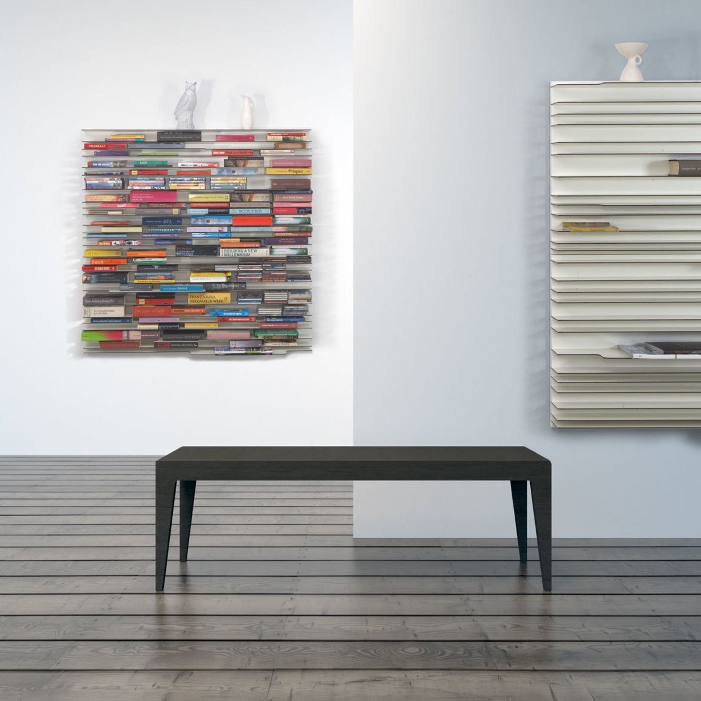 Stylish Spectrum Paperback shelving system featuring colorful books, complemented by a modern bench in a minimalist space.