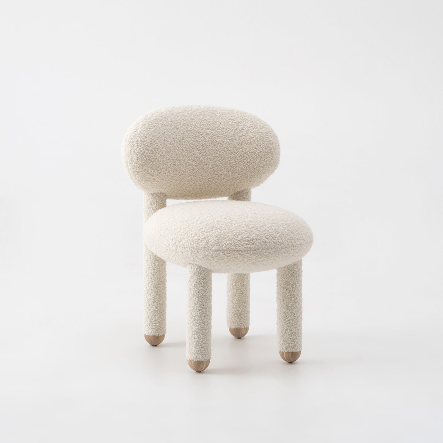Modern designer Flock dining chair by NOOM home, featuring soft, plush upholstery and rounded forms in a neutral color.