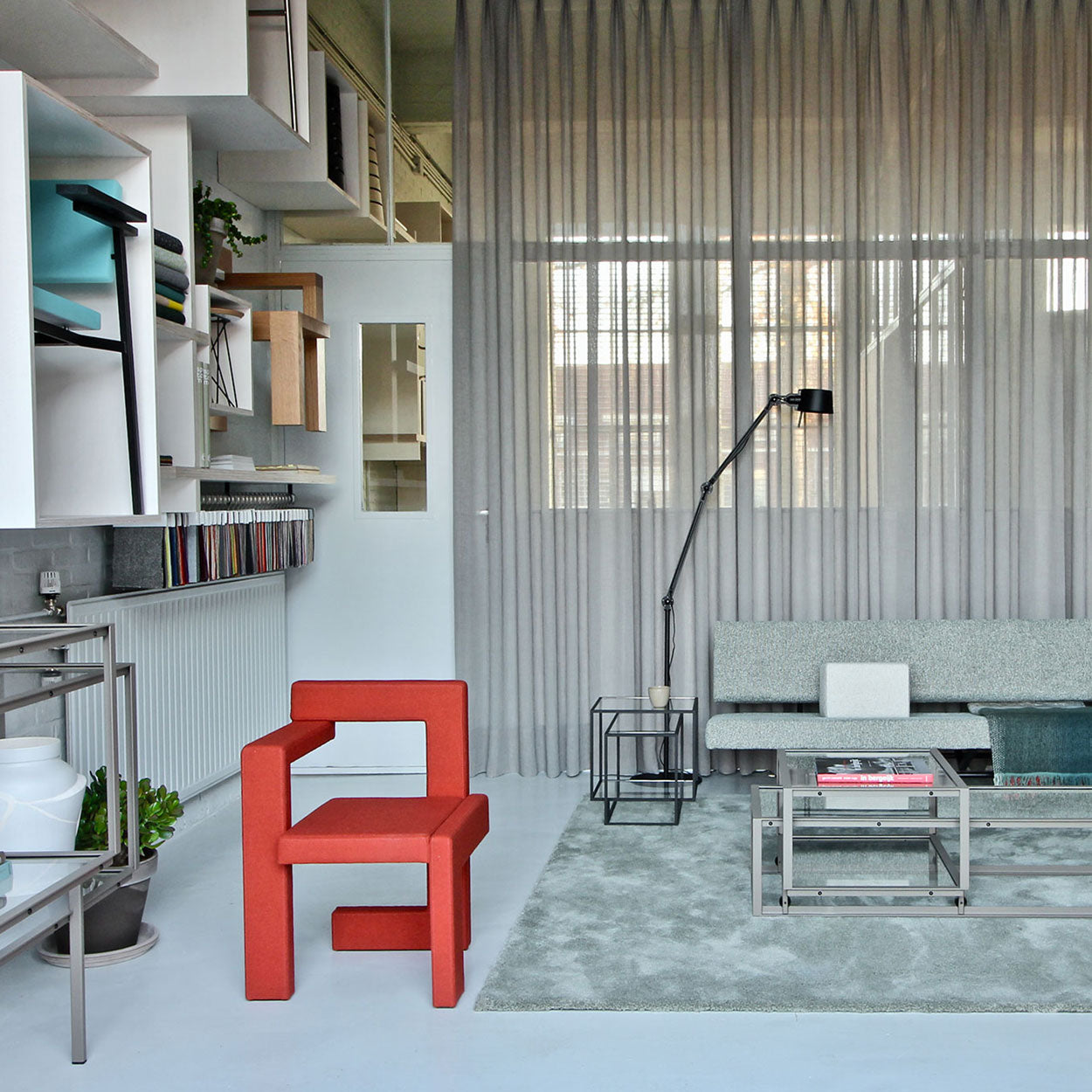 Modern living room featuring the wooden Steltman chair by Gerrit Rietveld, minimalist decor with gray curtains and sleek furniture.