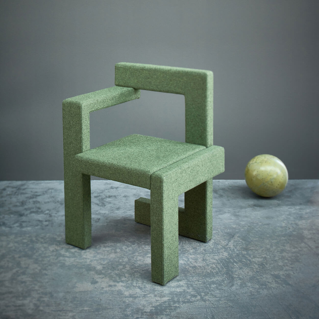 Modern green wooden Steltman chair designed by Gerrit Rietveld for Spectrum, displayed with a decorative sphere.