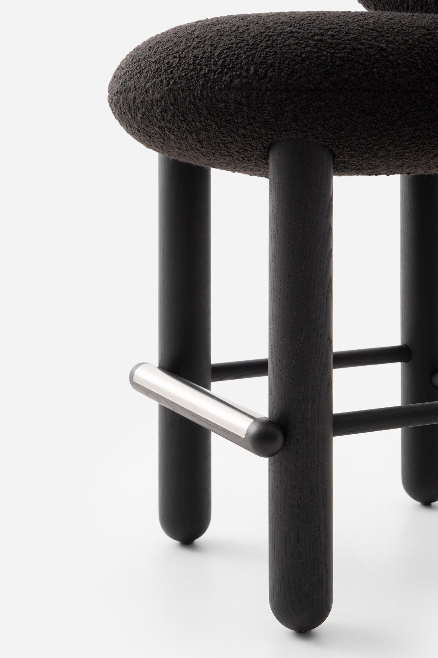 Modern designer Flock CS2 bar stool by Noom, featuring a soft seat and sleek black wood legs.