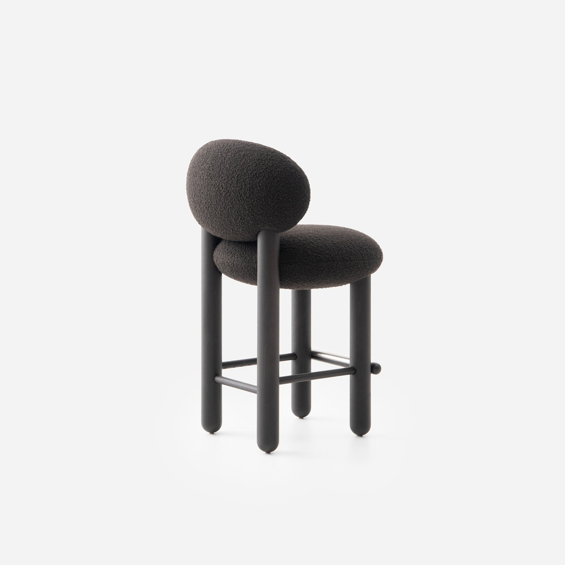 Modern designer Flock CS2 bar stool by Noom featuring a soft, curved seat and supportive back in black upholstery.