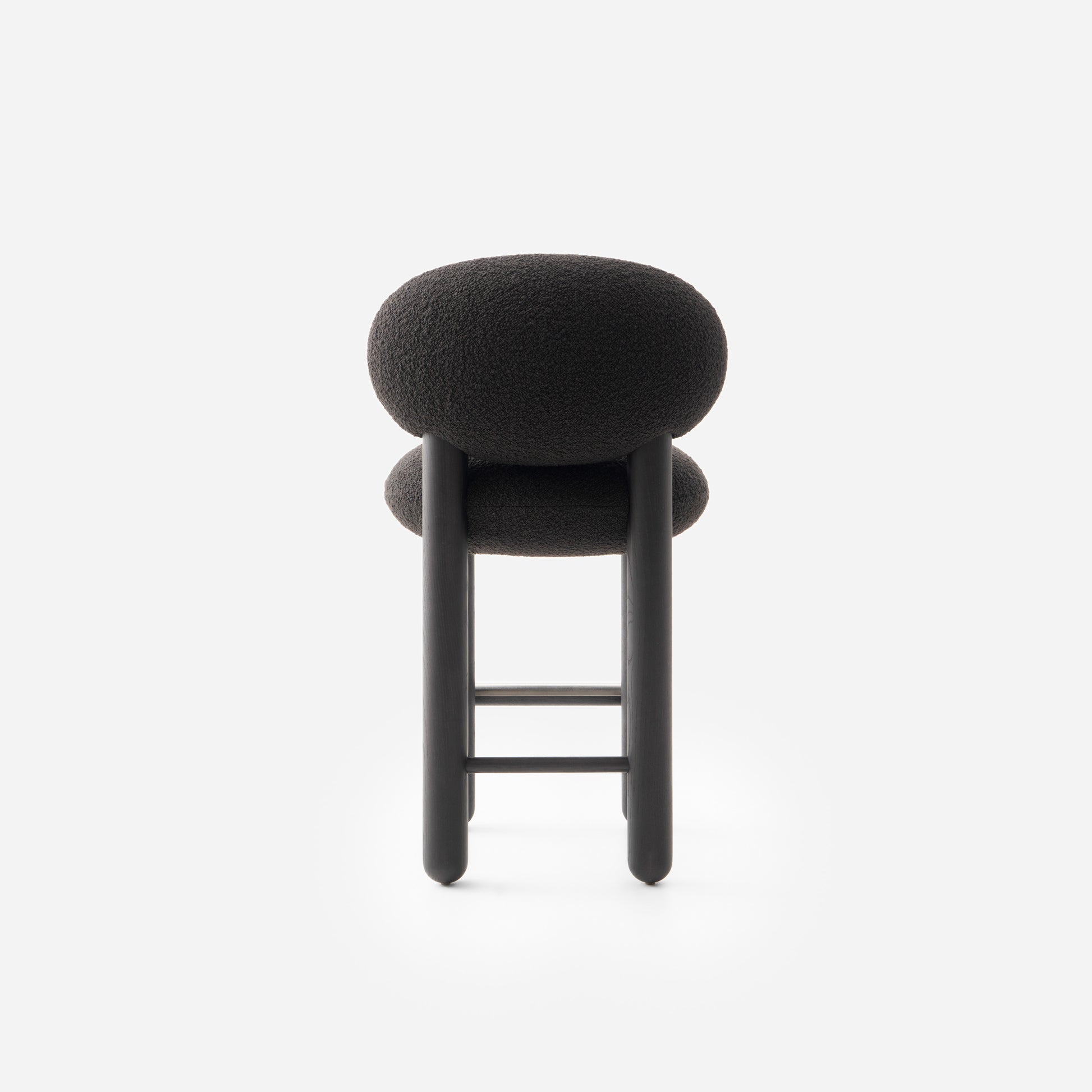 Modern Flock CS2 bar stool by Noom, featuring a soft black seat and sleek design, perfect for home or commercial interiors.