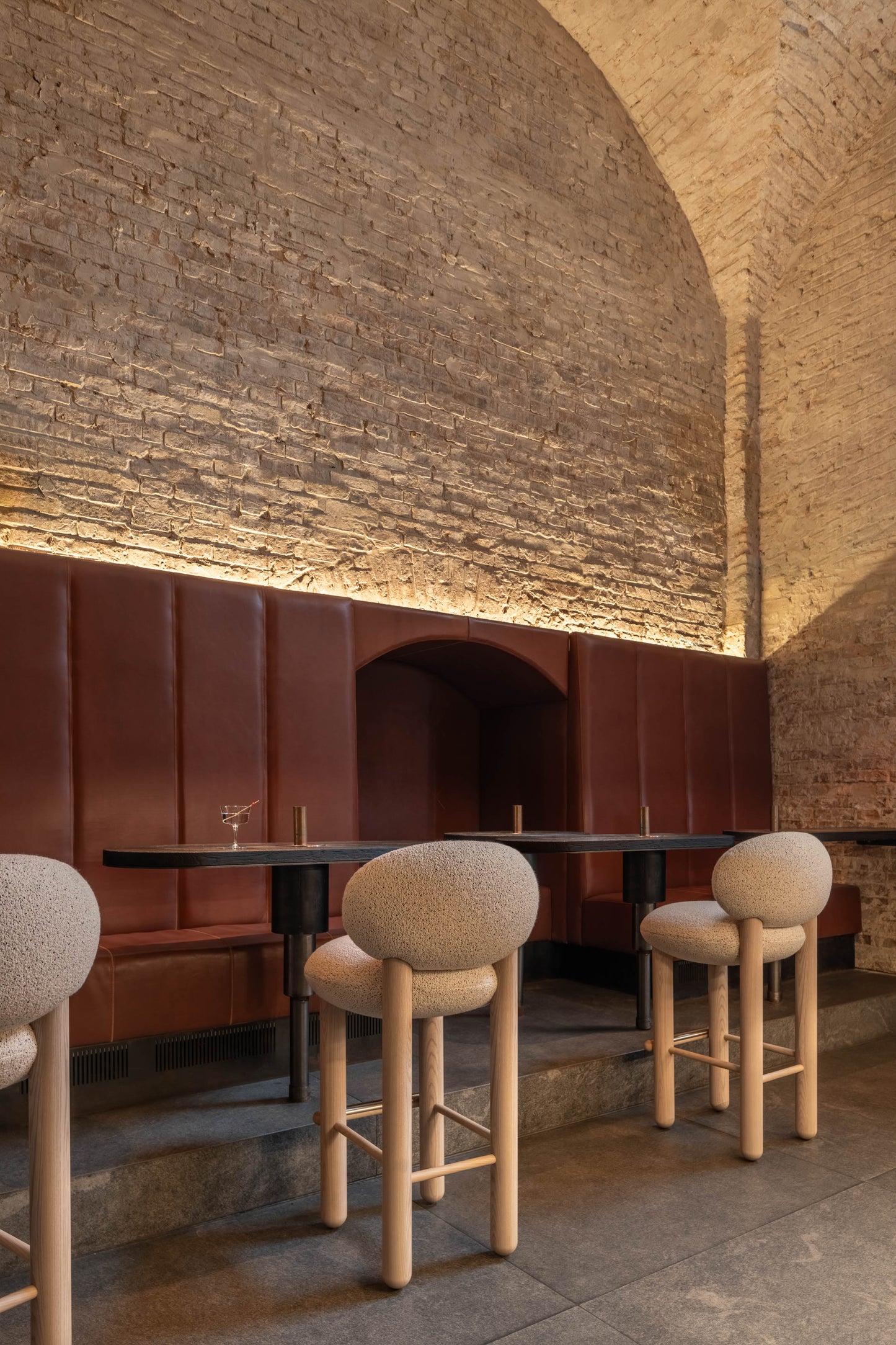 Modern Flock CS2 bar stools by Noom, featuring a deep seat and curved back, in a stylish restaurant setting.