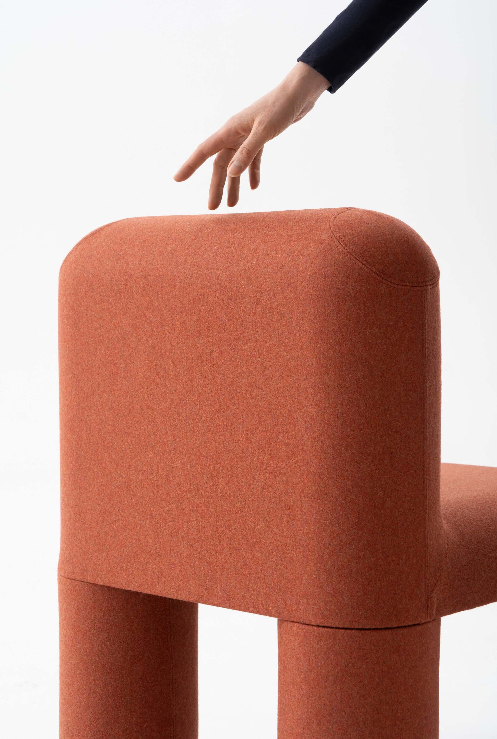 Modern HELLO chair by Noom with orange fabric and playful design, showcasing its rounded, comfortable backrest and unique structure.