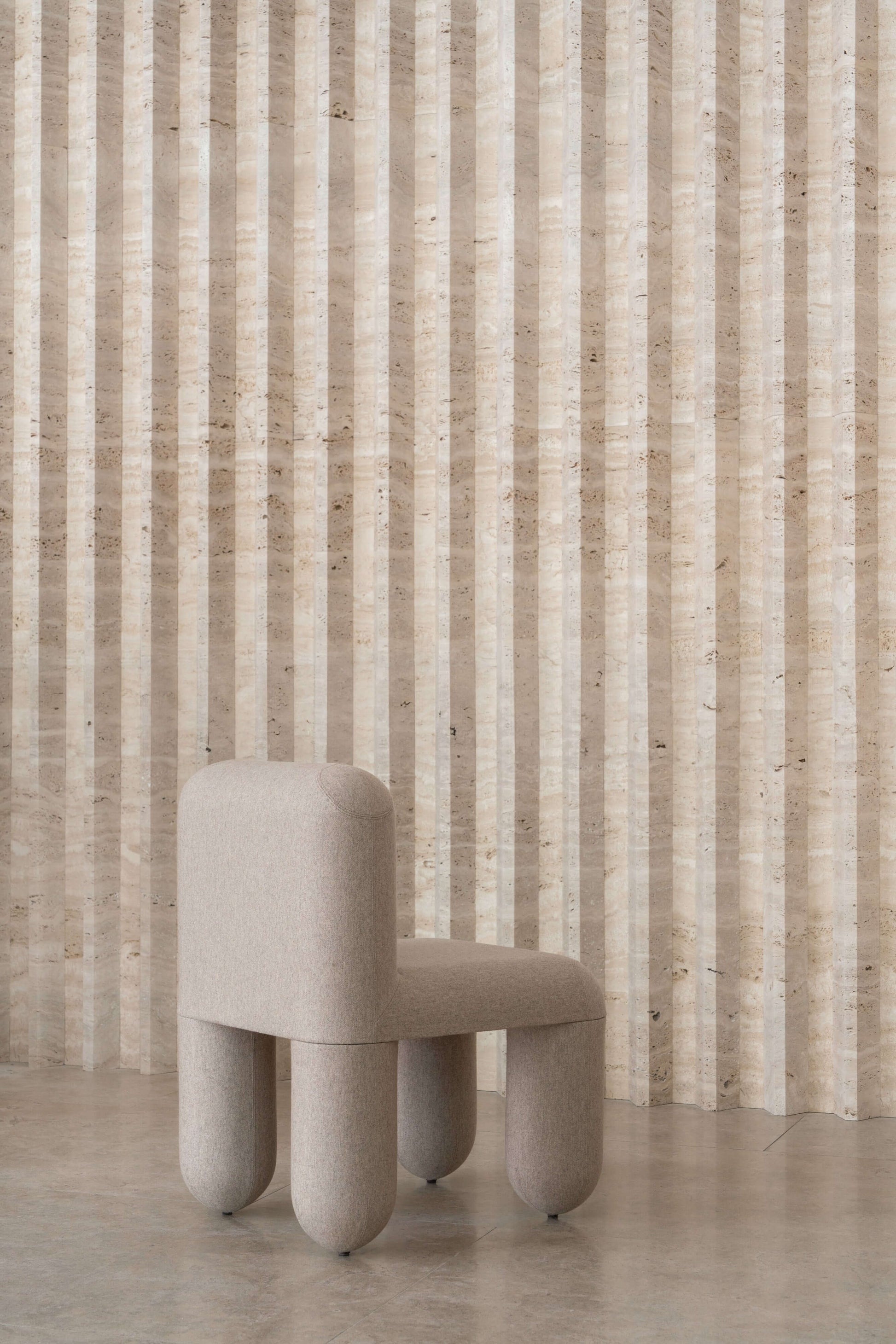 Modern HELLO chair by Denys Sokolov, featuring round organic shapes and plush comfort, showcased against a striped wall.