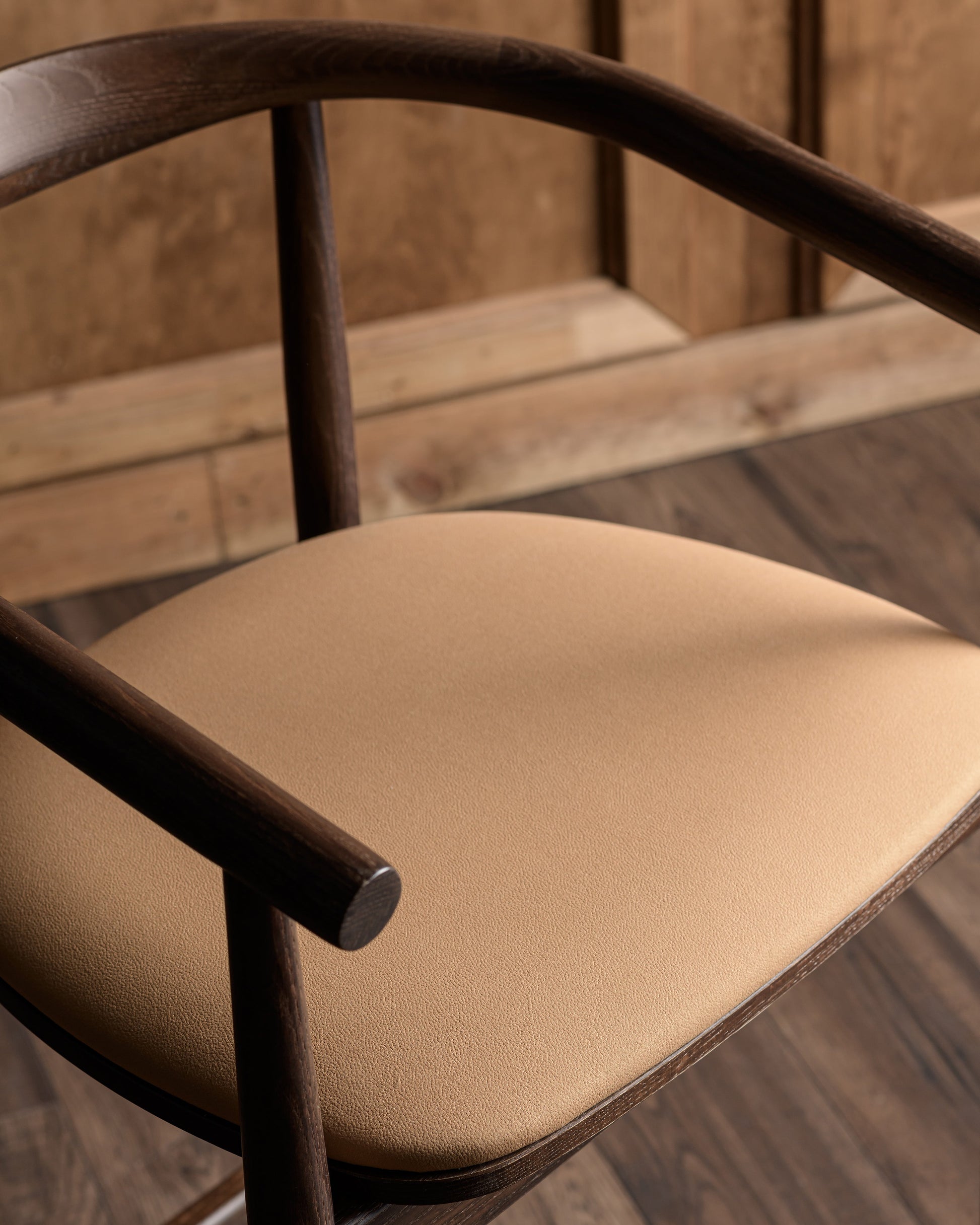 Chair with beige cushion and wooden frame on a wooden floor